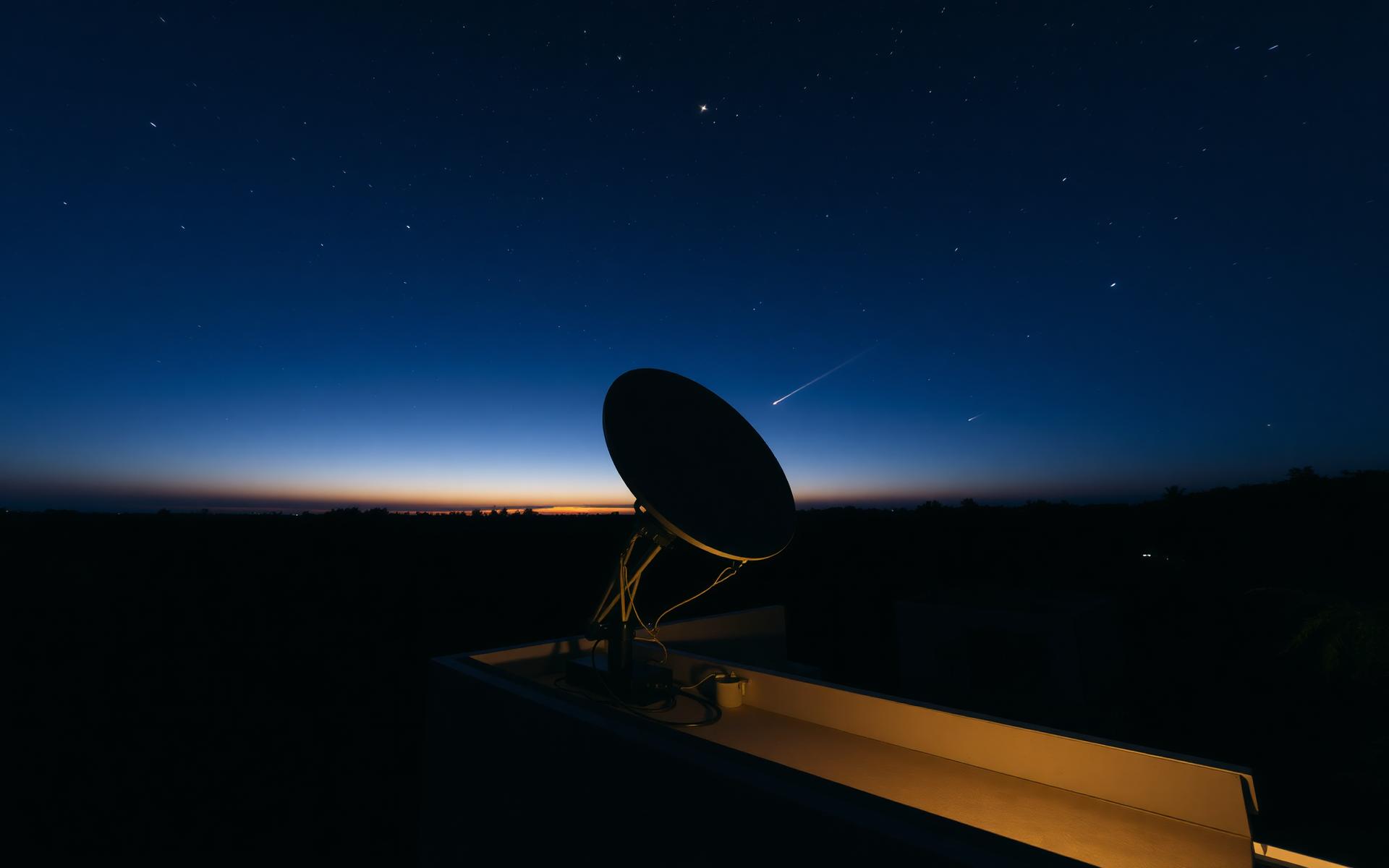 Antena Starlink instalada em telhado sob céu estrelado em Roraima